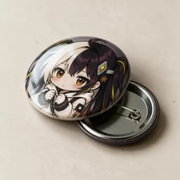 Round glow-in-the-dark tinplate badge photographed at a 45-degree angle to show the printed surface and metal edge, with a butterfly pin clasp beside it