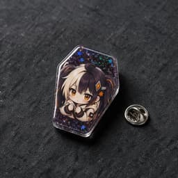 Coffin-shaped glitter holographic tinplate badge photographed at a 45-degree angle showing its contoured shape and holographic reflections, with a butterfly pin clasp beside it
