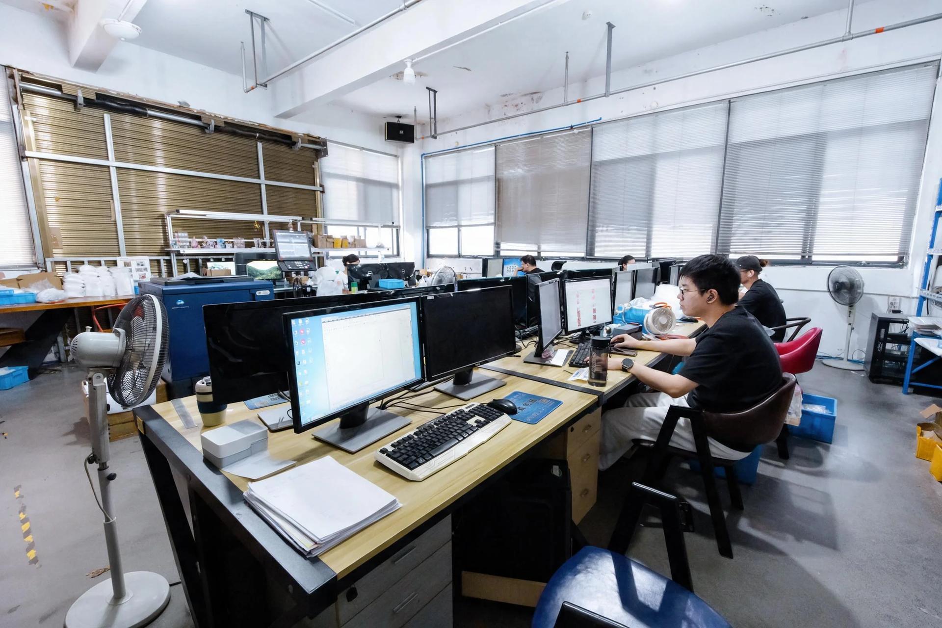 The artwork preflight bench: designs checked on multiple screens before a proof goes out