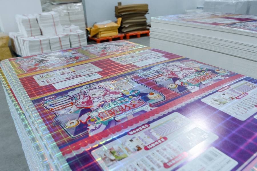 Freshly printed holographic sheets — the effect layer used for holographic charms
