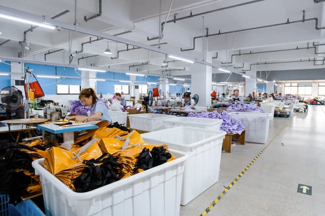 Sewing floor with rows of workstations for canvas bag production